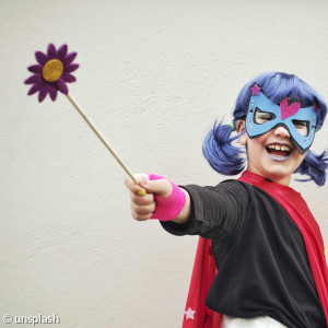 Ein Kind mit Maske und Zauberstab